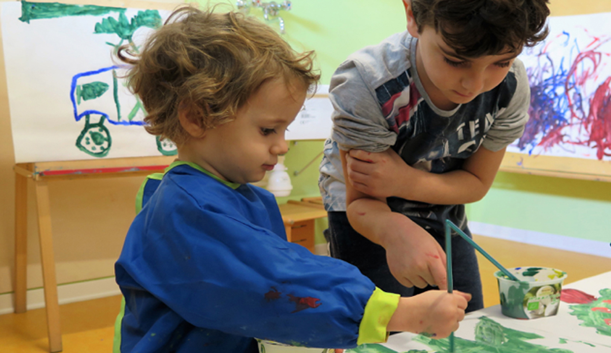 due bambini di età diverse che dipingono insieme
